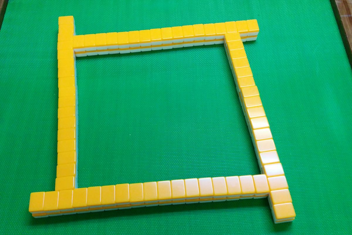 Tembok mahjong segi empat sama dibina di atas meja, langkah pertama dalam cara main mahjong